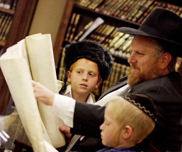 Rabbi Dov Tanzer, rosh yeshivah of Yeshiva College in Glenhazel, Johannesburg, reads the Megillah to his children on Purim.