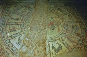 The central panel of the ancient mosaic floor of the synagogue in Hamat Tiberias National Park depicts the twelve signs of the zodiac with a Hebrew inscription for each. In the center is the Greek sun god, Helios. A woman’s face is portrayed in each of the four corners along with a Hebrew inscription indicating the season in the solar calendar (Tishrei, Tevet, Nisan and Tammuz corresponding to fall, winter, spring and summer).