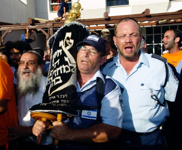 P.M ARIEL SHARON'S DISENGAGEMENT PLAN. IN PHOTO, ATZMONA RESIDENTS AND POLICEMEN REMOVING TORAH SCROLLS FROM THE SYNAGOGUE SHORTLY BEFORE THE EVACUATION BEGINS. úåëðéú ääúðú÷åú ùì øàù äîîùìä àøé÷ ùøåï îçáì òæä åöôåï äùåîøåï. áöéìåí, úåùáé äéùåá òöîåðä åùåèøé îùèøú éùøàì îôðéí àú ñôøé äúåøä îáéú äëðñú áéùåá, ì÷øàú ôéðåé äéùåá îúåùáéå.