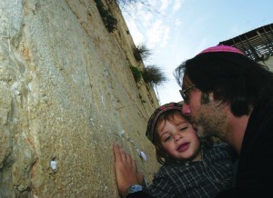 A French immigrant kisses his son as he prays at the Western Wall in Jerusalem after arriving in Israel.